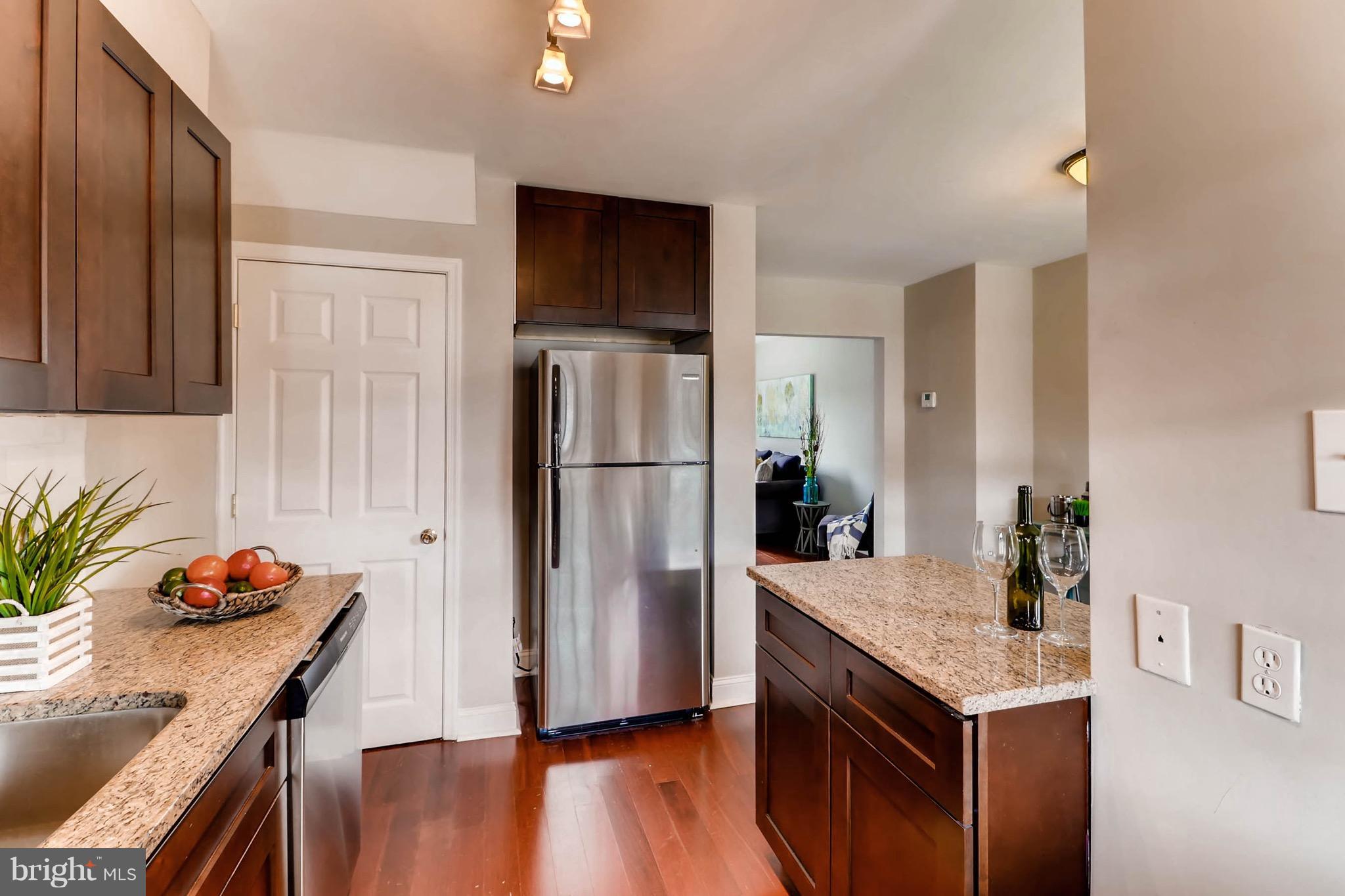 2107 Redthorn Road Baltimore, MD 21220 - Photo 6 of 14 a kitchen with granite countertop a refrigerator a stove and wooden floor