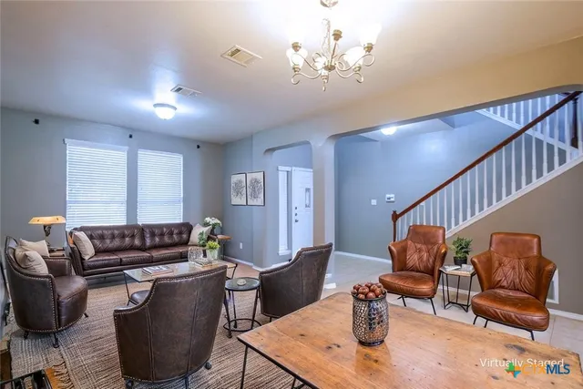 a living room with furniture and a chandelier