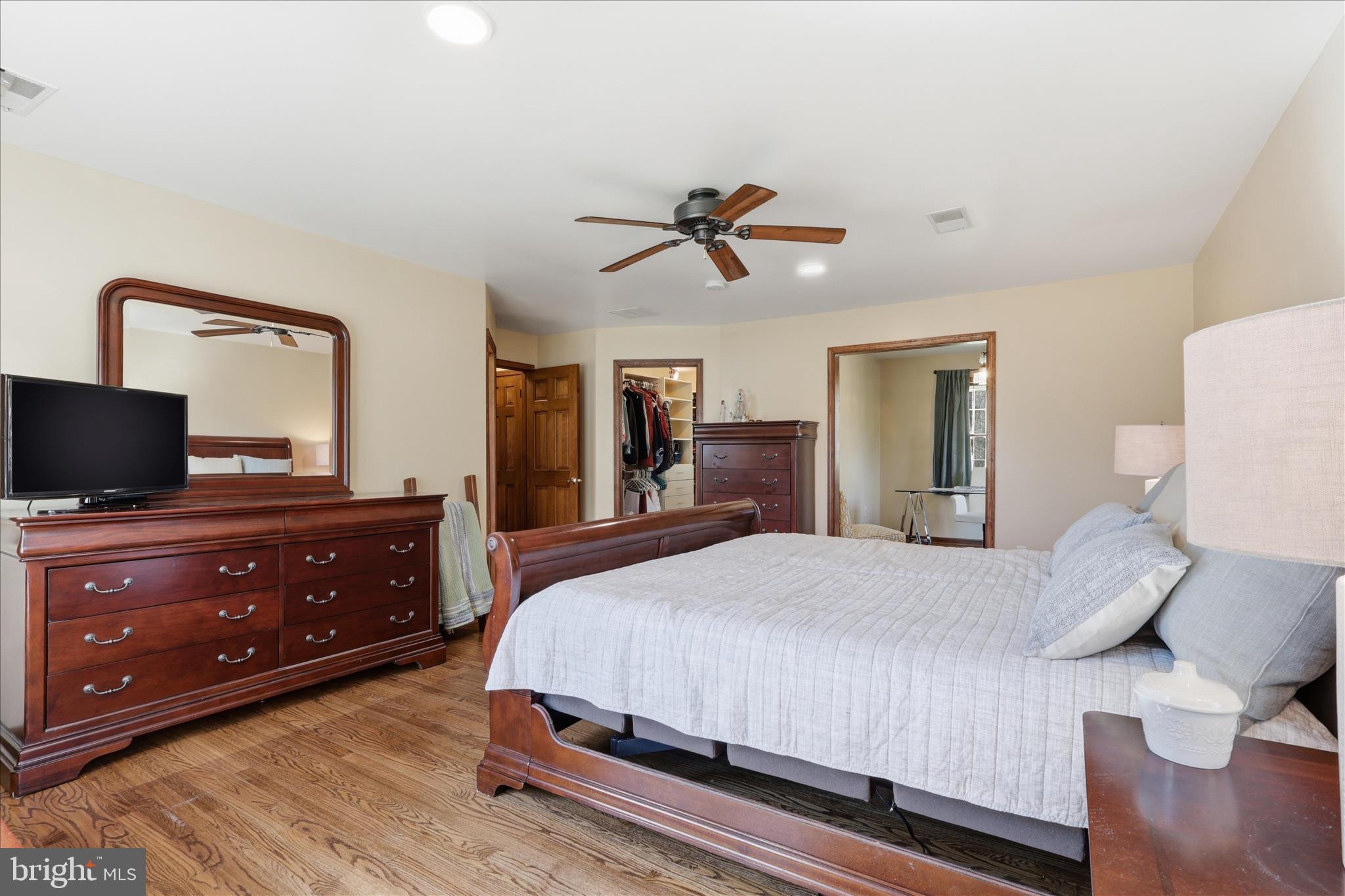 5605 Smoke Rise Lane Fairfax Station, VA 22039 - Photo 35 of 85 a bedroom with a bed and a dresser with mirror