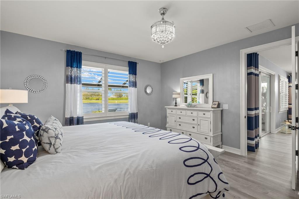 14651 Topsail Drive Naples, FL 34114 - Photo 12 of 37 a bedroom with a bed and a chandelier