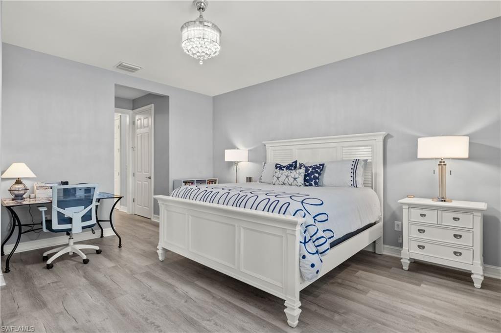 14651 Topsail Drive Naples, FL 34114 - Photo 13 of 37 a bedroom with a bed and a table in it