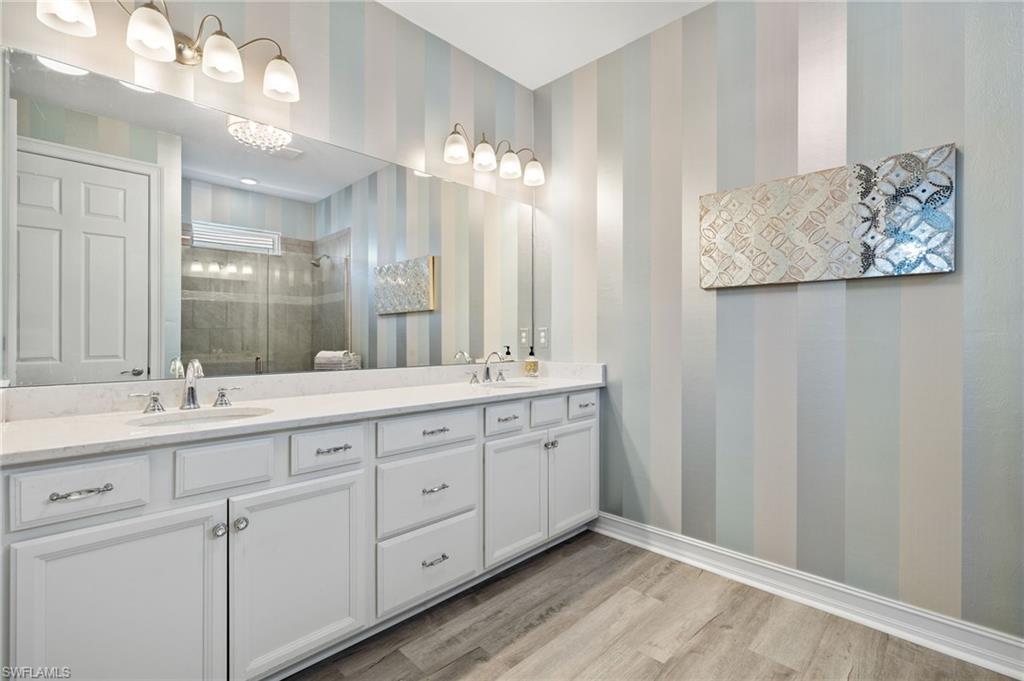 14651 Topsail Drive Naples, FL 34114 - Photo 14 of 37 a bathroom with a double vanity sink and a mirror