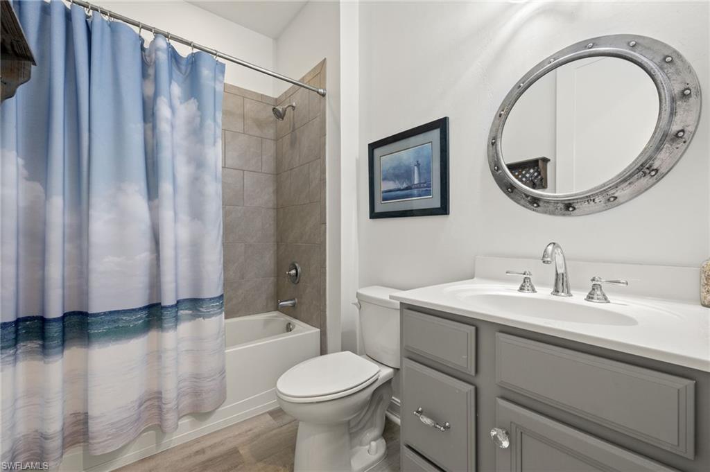 14651 Topsail Drive Naples, FL 34114 - Photo 17 of 37 a bathroom with a sink a toilet and a mirror