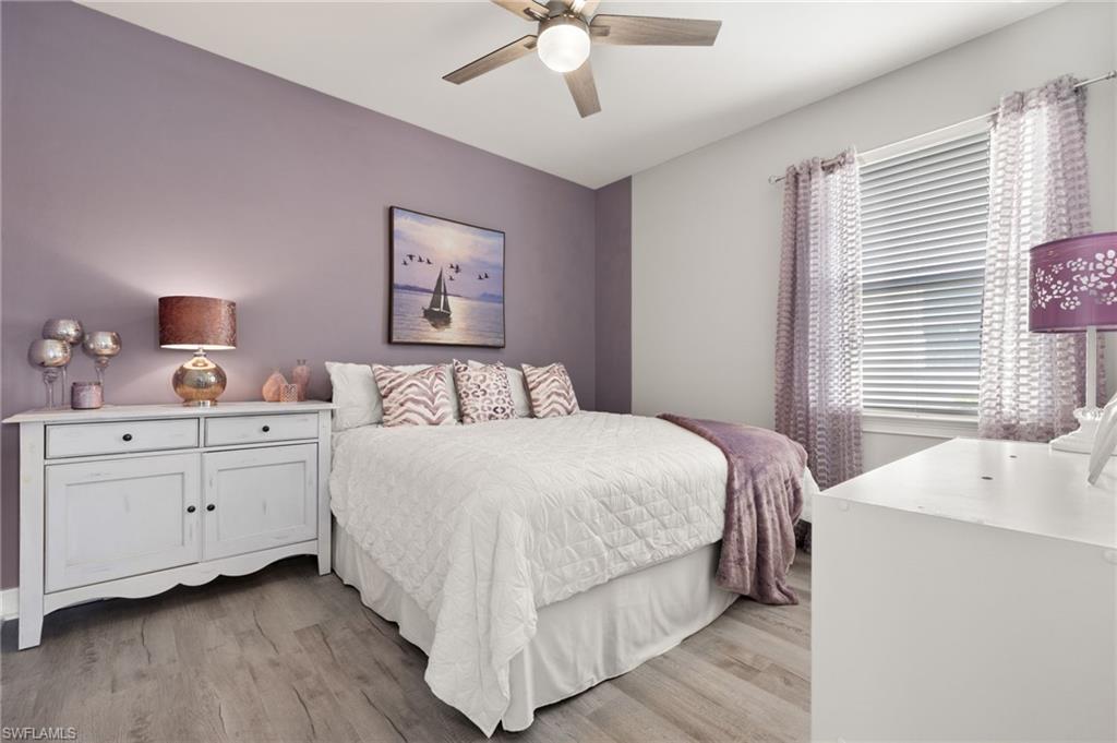 14651 Topsail Drive Naples, FL 34114 - Photo 18 of 37 a bedroom with a large bed and a chandelier