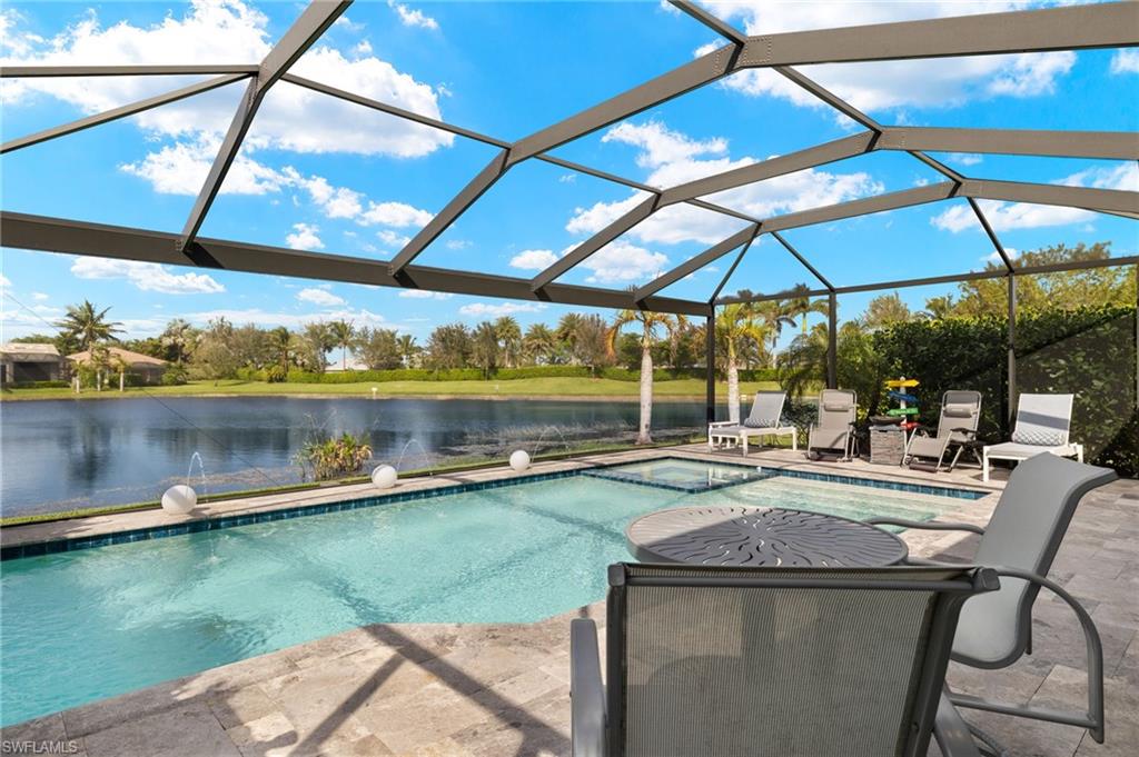 14651 Topsail Drive Naples, FL 34114 - Photo 24 of 37 a view of a lake with a table and chairs under an umbrella