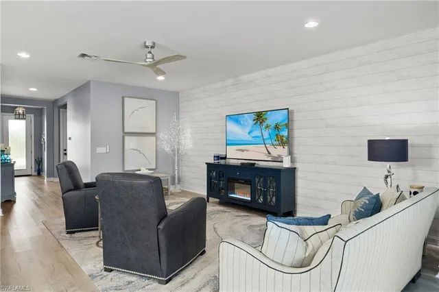 a living room with furniture a flat screen tv and a fireplace