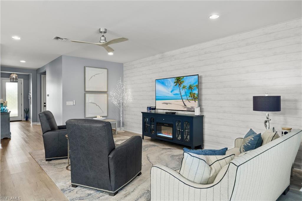 14651 Topsail Drive Naples, FL 34114 - Photo 3 of 37 a living room with furniture a flat screen tv and a fireplace