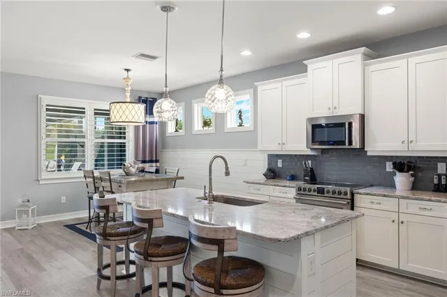 a kitchen with granite countertop a sink a stove and cabinets