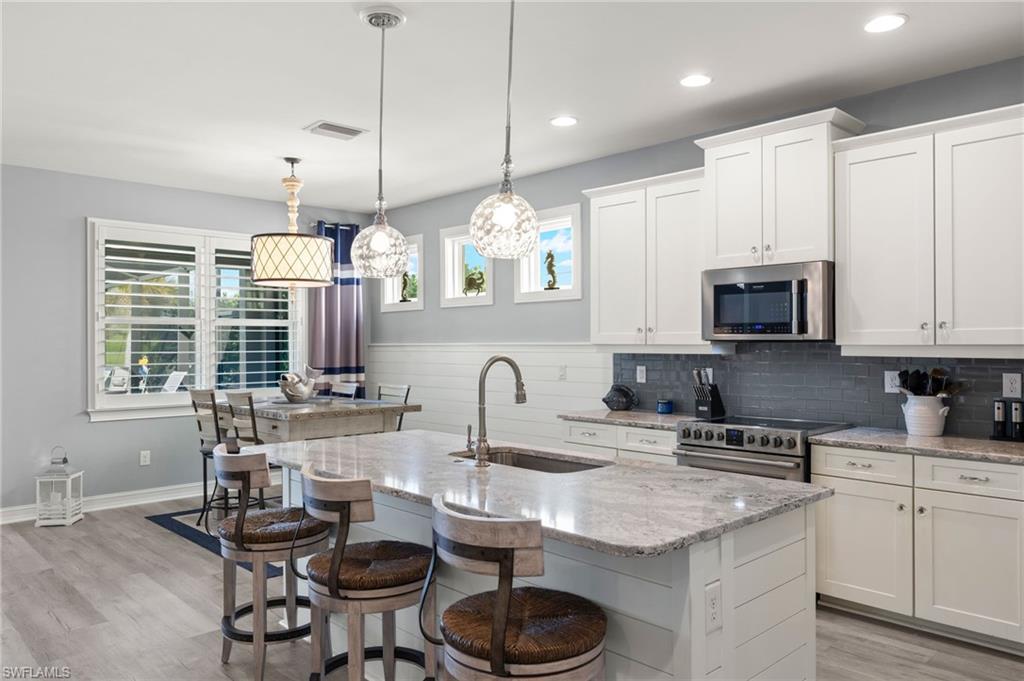 14651 Topsail Drive Naples, FL 34114 - Photo 6 of 37 a kitchen with granite countertop a sink a stove and cabinets