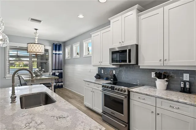 a kitchen with granite countertop a sink stainless steel appliances and cabinets