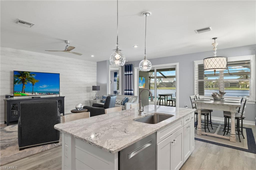 14651 Topsail Drive Naples, FL 34114 - Photo 9 of 37 a kitchen with sink cabinets and living room view