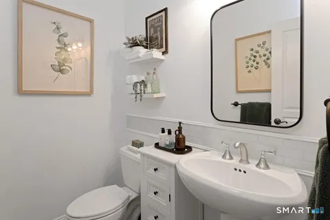 a bathroom with a toilet sink and mirror