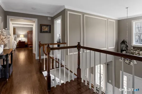 a view of a hallway with wooden floor and stairs