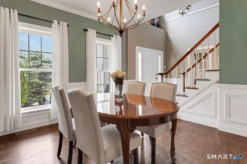 a view of a dining room with furniture a chandelier and wooden floor