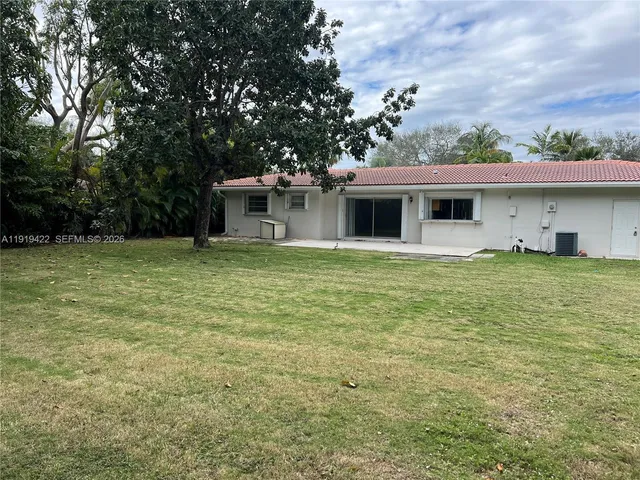 a white house that has a tree in front of it