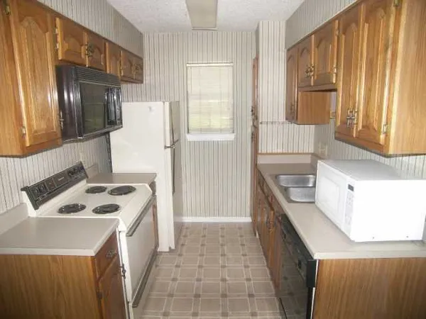 a kitchen that has a sink a stove and a refrigerator