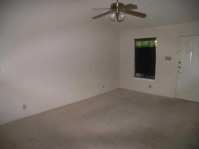 a view of a room with a ceiling fan and a window