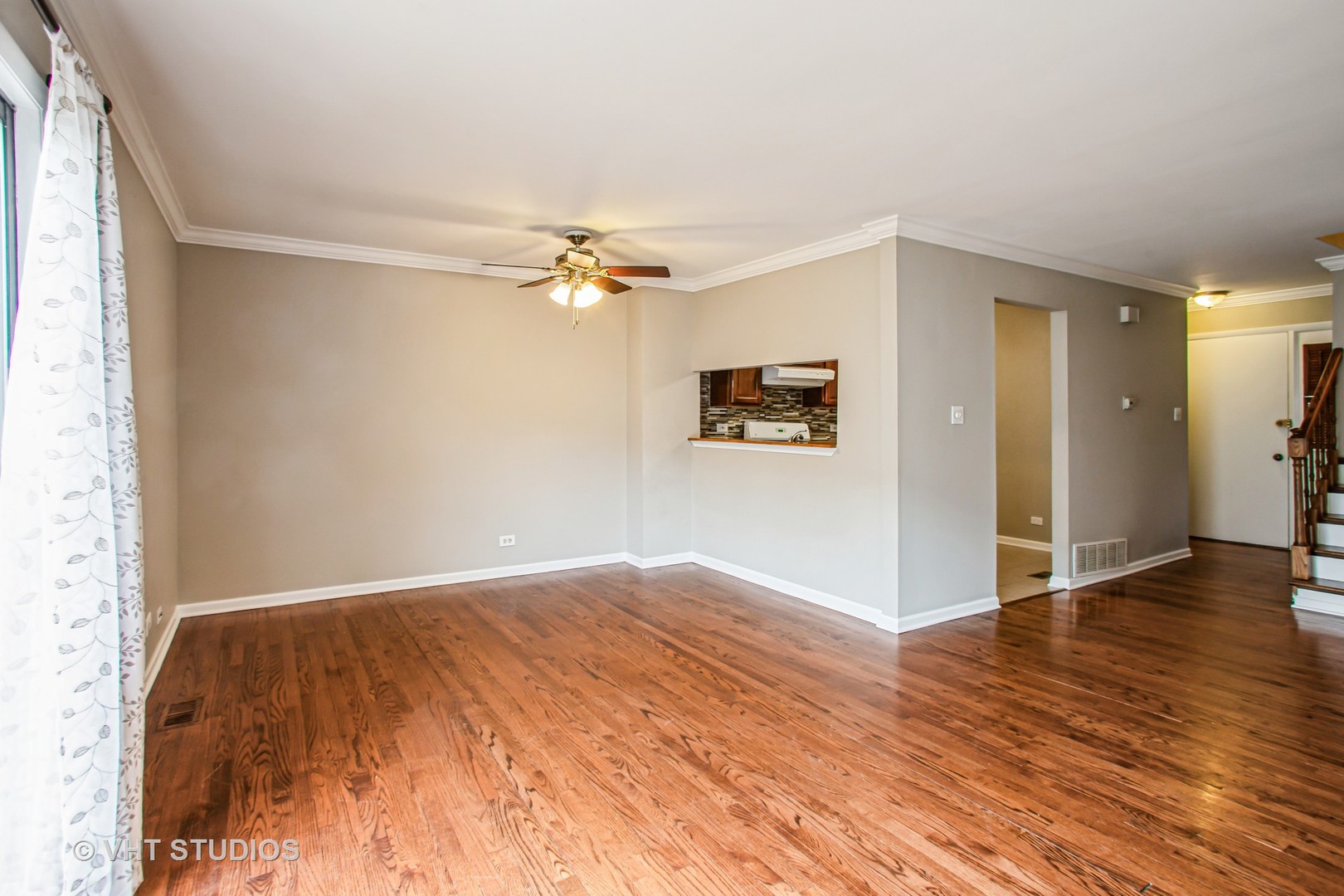 1660 Darwin Court Wheaton, IL 60189 - Photo 5 of 17 an empty room with wooden floor chandelier fan and windows