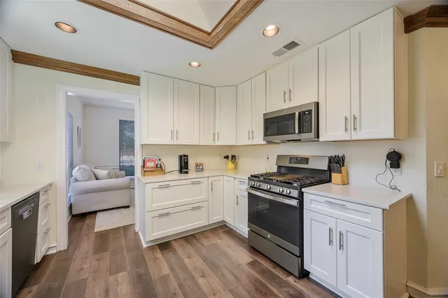a kitchen with white cabinets and appliances