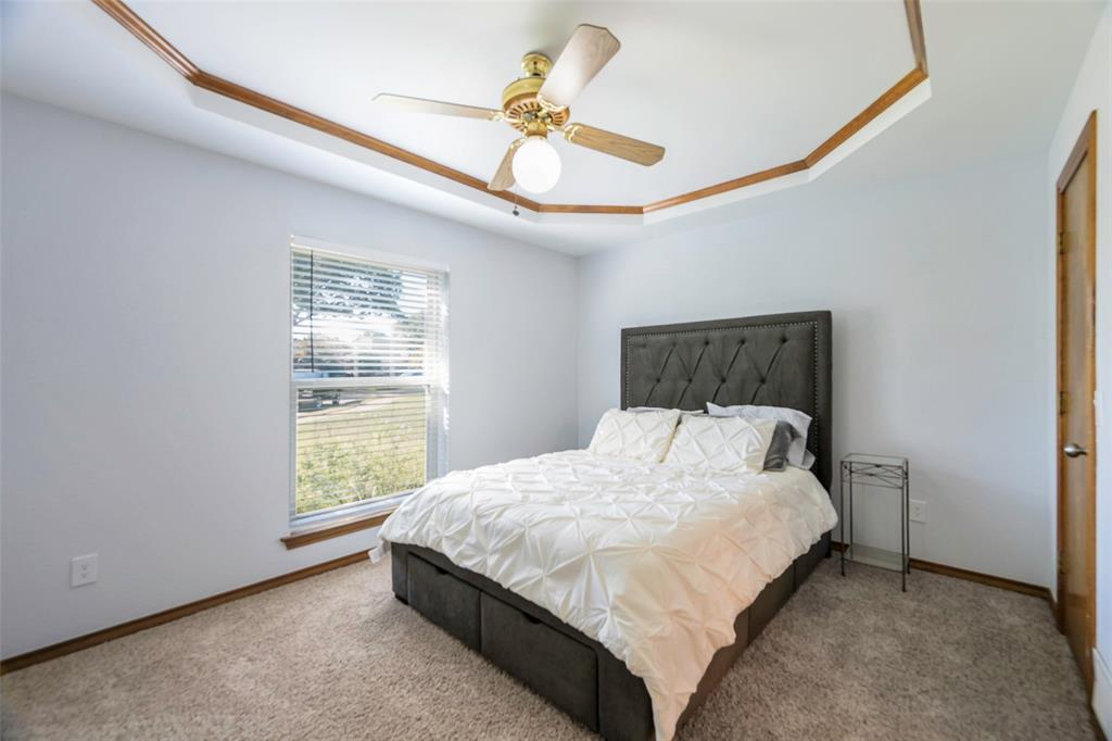925 Spring Brook Drive Allen, TX 75002 - Photo 24 of 26 a bedroom with a bed and a chandelier