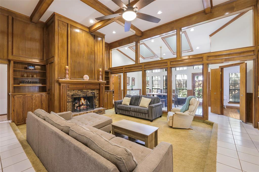 925 Spring Brook Drive Allen, TX 75002 - Photo 5 of 26 a living room with furniture a fireplace and a floor to ceiling window