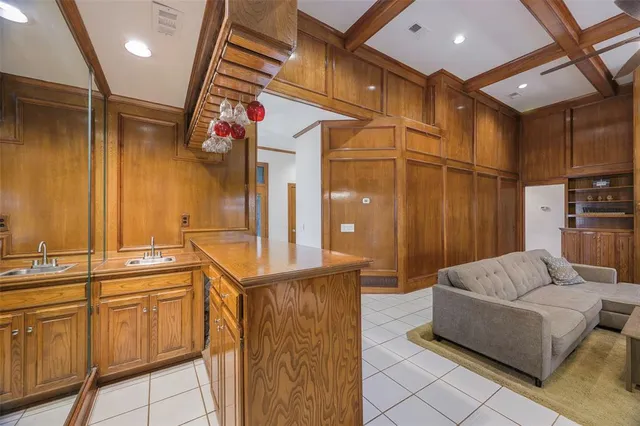 a living room with furniture a flat screen tv and a sink