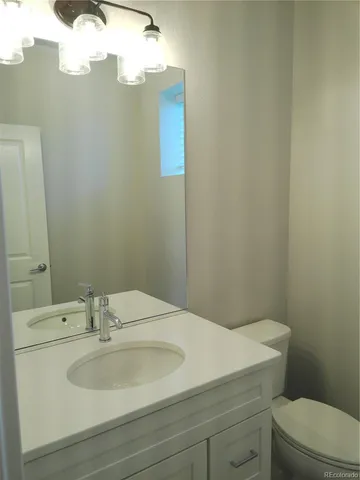 a bathroom with a sink a toilet and mirror