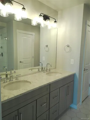 a bathroom with a granite countertop sink double and mirror