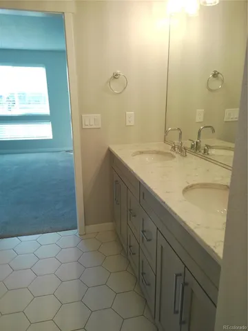 a bathroom with a granite countertop sink and a mirror