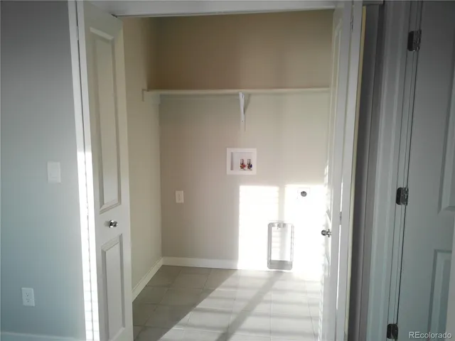 a view of a hallway with wooden floor and a bathroom