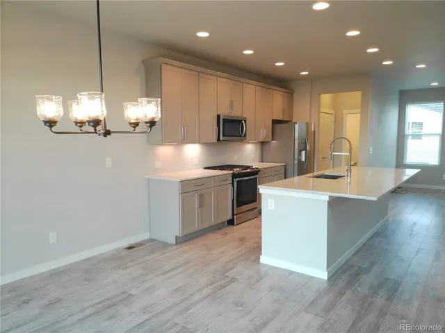 a kitchen with kitchen island a sink stainless steel appliances and cabinets