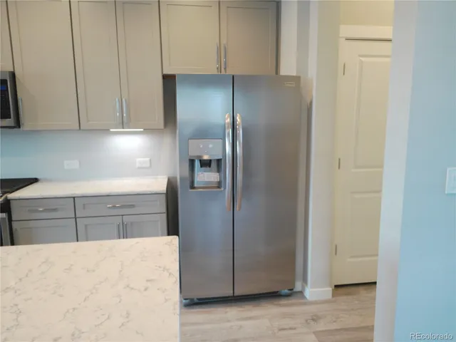 a kitchen with a refrigerator stove and cabinets