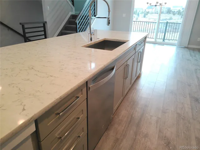 a kitchen with a sink and wooden floor