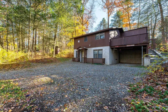 a view of a house with a yard and large tree