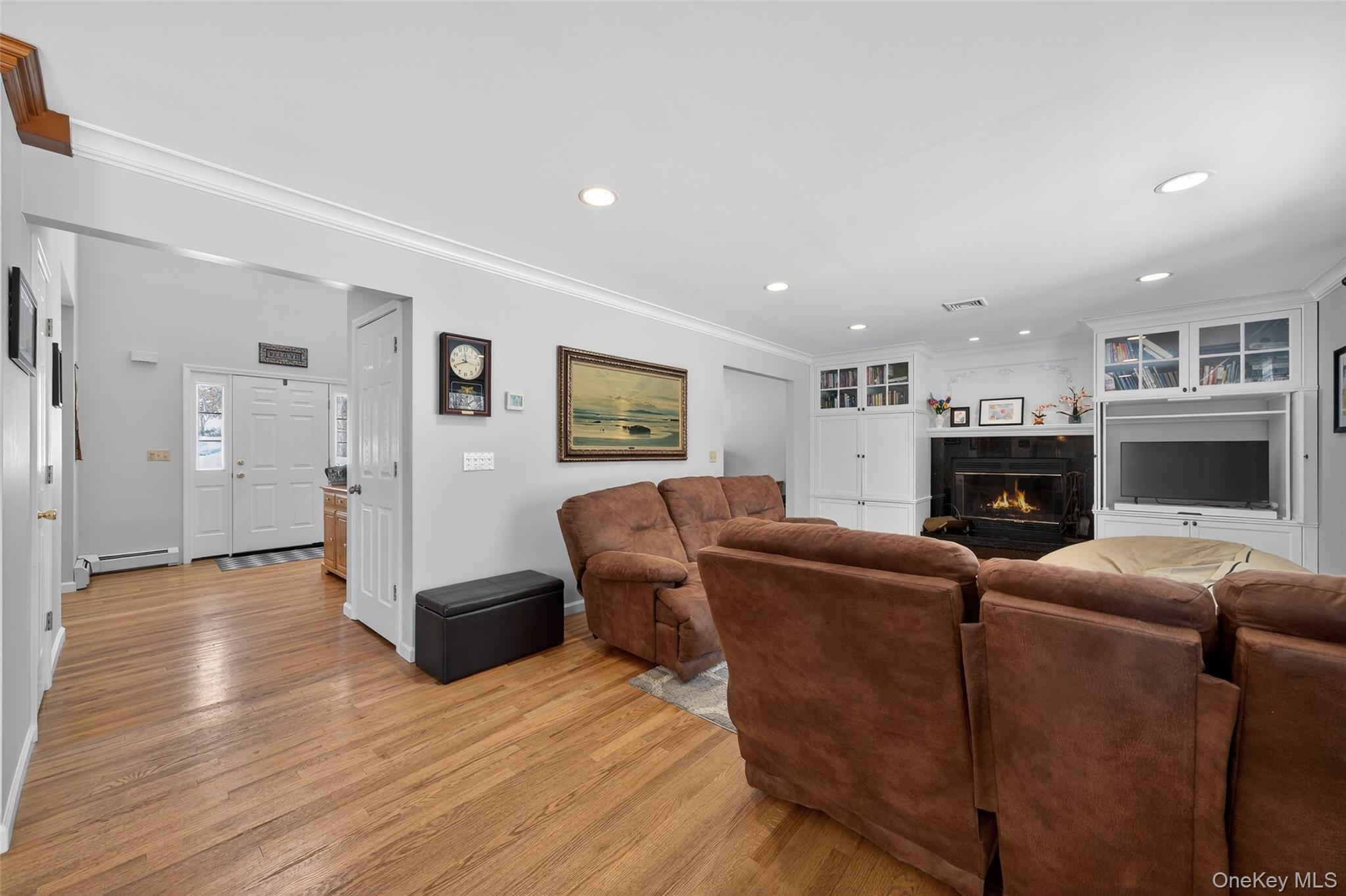 34 Booth Road Chester, NY 10918 - Photo 15 of 42 Living area with crown molding, wood floors, fireplace, recessed lighting, and built in cabinetry