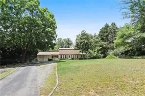 a view of a house with a yard and sitting area