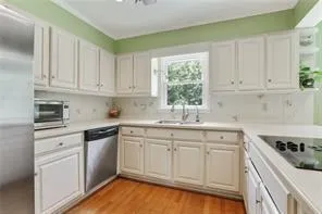 a kitchen with white cabinets sink and white appliances