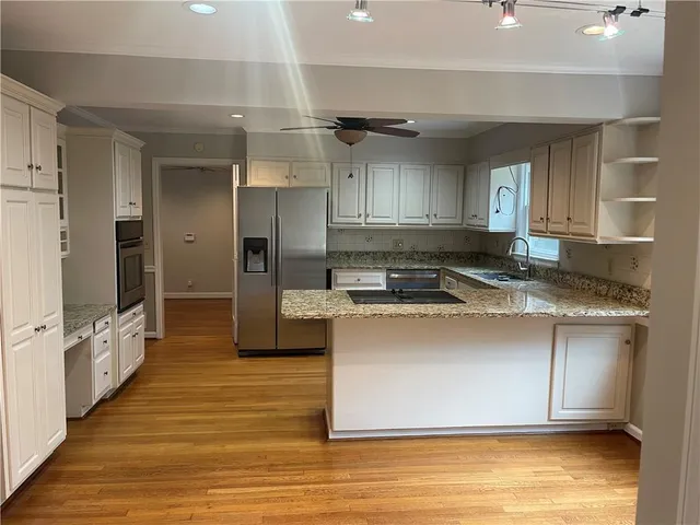 a kitchen with stainless steel appliances granite countertop a stove a sink and a refrigerator
