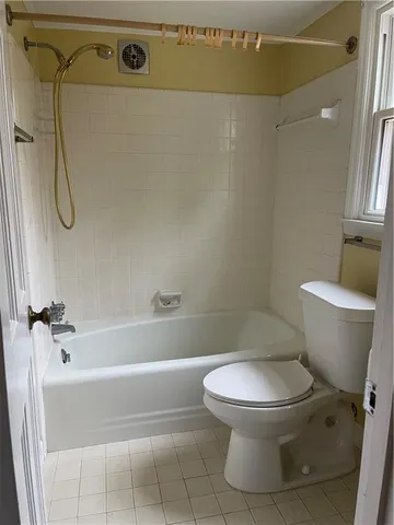 a white toilet sitting next to a bath tub shower