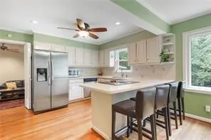 a kitchen with a table chairs refrigerator and cabinets