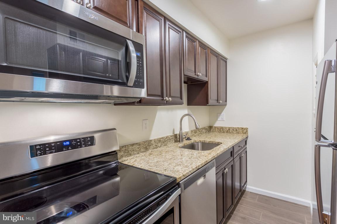 8110 Colony Point Road, Unit K Springfield, VA 22152 - Photo 11 of 30 a kitchen with a stove and a microwave