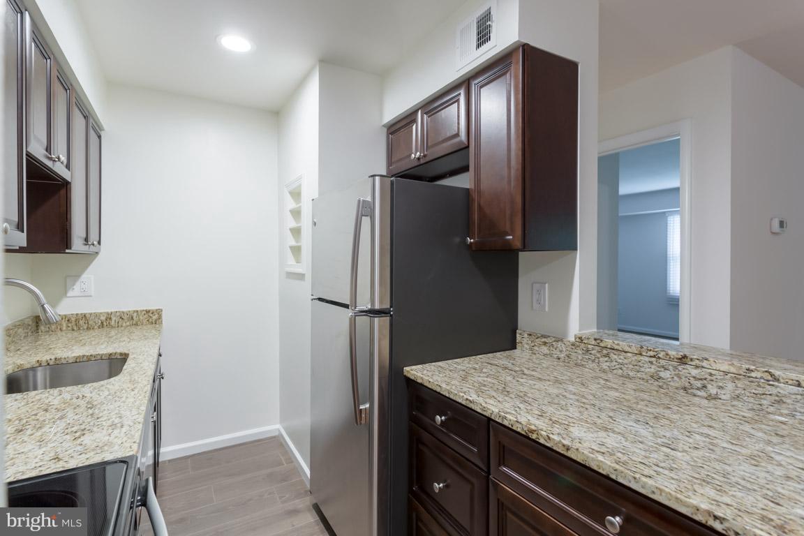8110 Colony Point Road, Unit K Springfield, VA 22152 - Photo 12 of 30 a kitchen with a granite countertop sink refrigerator and microwave