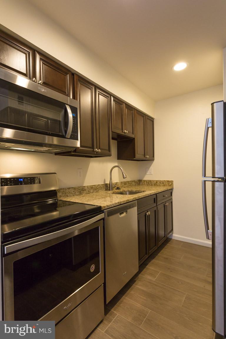 8110 Colony Point Road, Unit K Springfield, VA 22152 - Photo 13 of 30 a kitchen with stainless steel appliances granite countertop a stove microwave and refrigerator