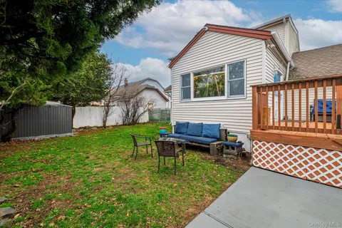 a backyard of a house with wooden fence and a bench