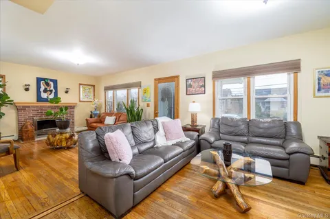 a living room with fireplace furniture and a large window