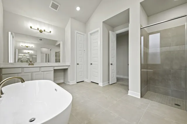 a bathroom with a bathtub and a double vanity sink mirror