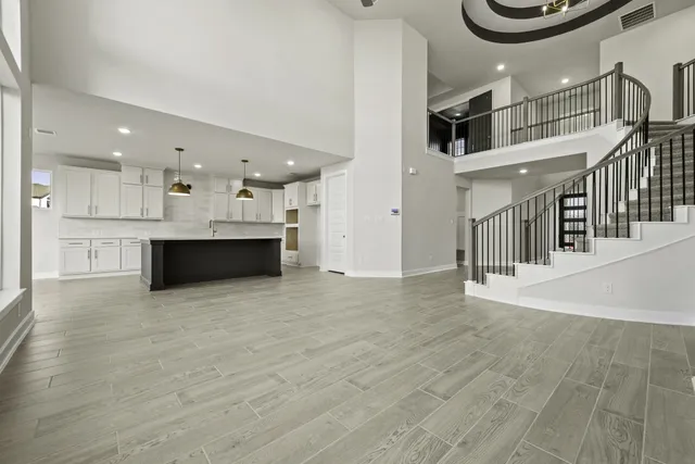 a view of a kitchen with kitchen island a sink wooden floor and stainless steel appliances