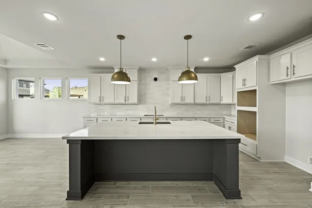a large kitchen with granite countertop a sink and a stove