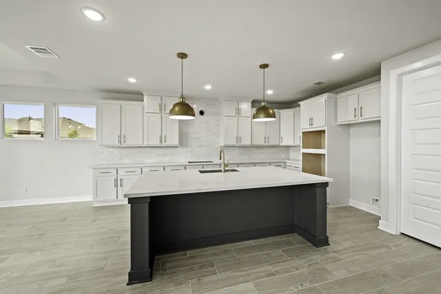 a kitchen with kitchen island a sink stainless steel appliances and cabinets