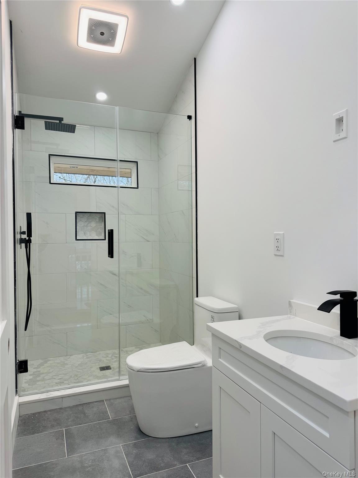 105 Old Riverhead Road Hampton Bays, NY 11946 - Photo 15 of 18 Full bath with vanity, a marble finish shower, dark tile patterned flooring, and recessed lighting